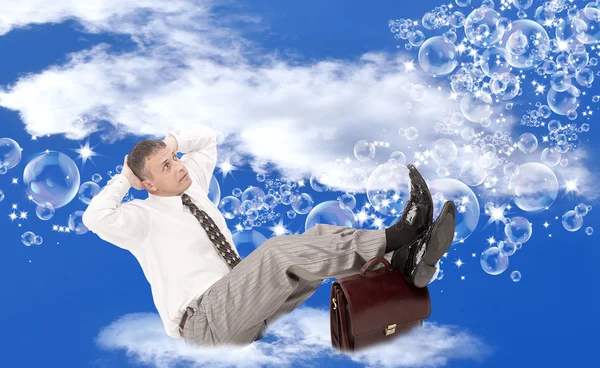 Rosa jabón sueña con una vida feliz del hombre de negocios sentado en una nube blanca esponjosa —  Fotos de Stock