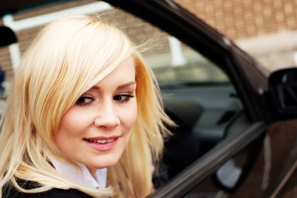 Smiling woman driver at wheel of car
