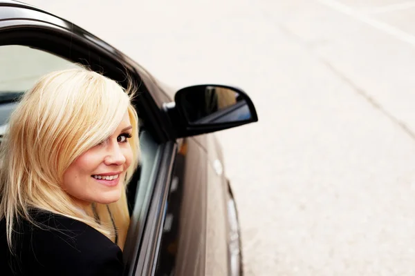 Lachende vrouw bestuurder achter het stuur van auto — Stockfoto