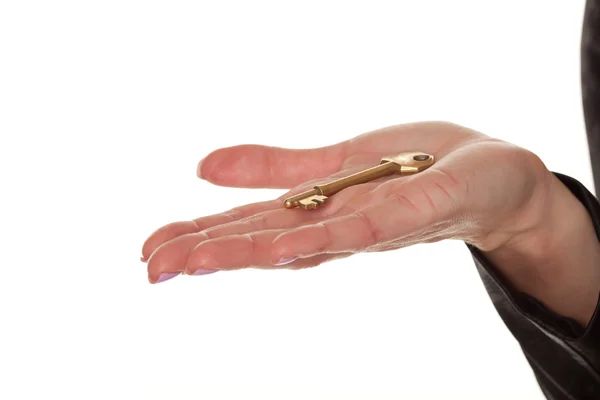 Жіноча рука, що показує латунний ключ — стокове фото