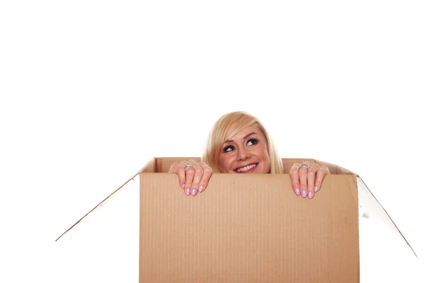 Attractive young blonde emerging from a box — Stock Photo, Image