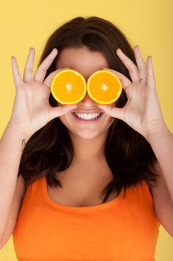 Joyful Woman With Orange Slices Over Eyes clipart