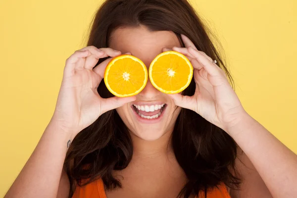 Lachende vrouw met oranje segmenten over ogen — Stockfoto