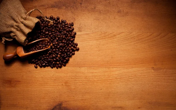 Granos de café tostados en madera —  Fotos de Stock