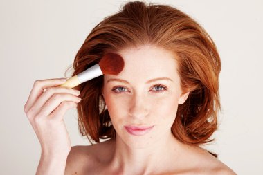 Woman Applying Face Powder clipart