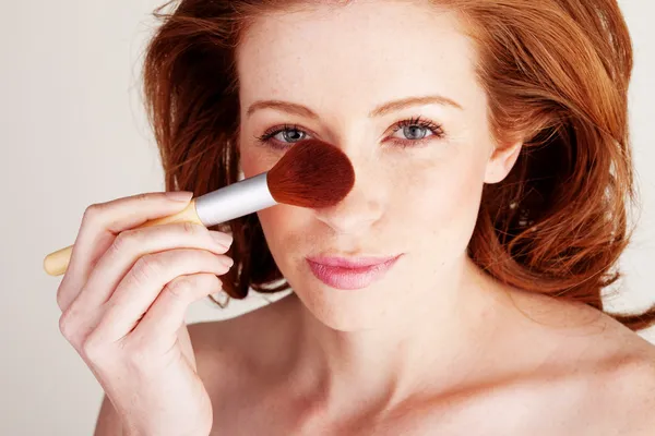 Mulher aplicando maquiagem com escova grande — Fotografia de Stock