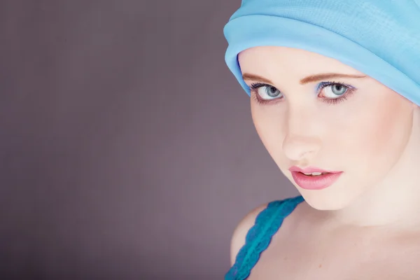 Женщина с голубой тканью обернутой вокруг головы — стоковое фото