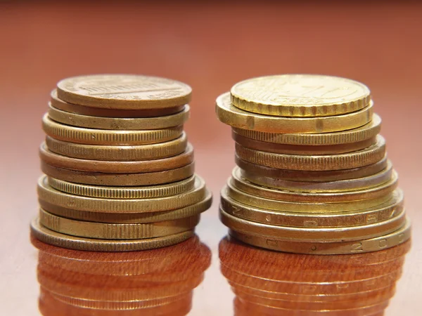 Stapel verschiedener Münzen auf einem polierten Tisch. — Stockfoto