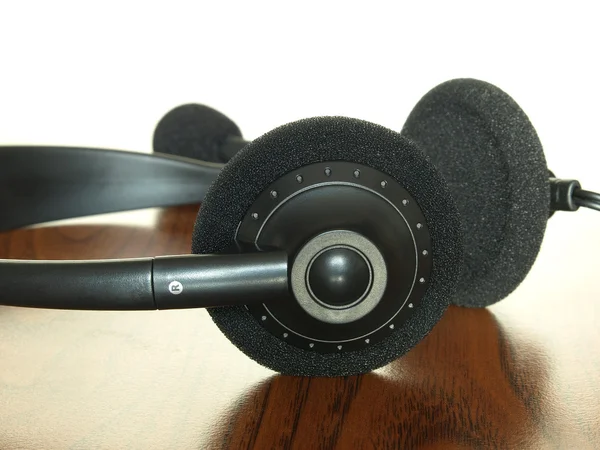 Černá sluchátka na dřevěný stůl. — Stock fotografie