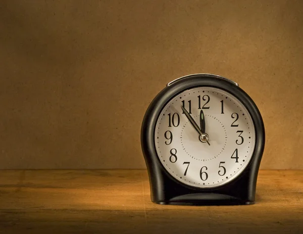 Reloj despertador negro en una mesa de madera . —  Fotos de Stock
