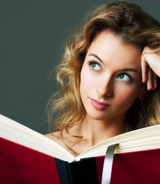 Mujer rubia joven con libro sobre fondo gris — Foto de Stock