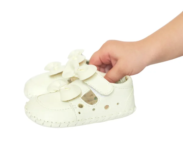 Kids hand holds small white baby shoes, studio shoot isolated — Stock Photo, Image