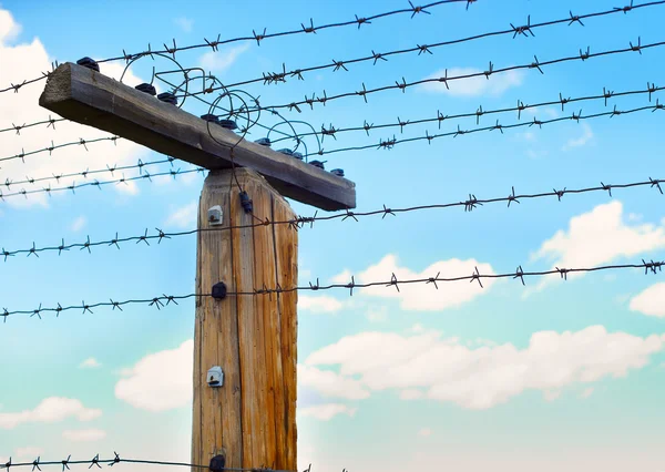 Post with barbed wire in the blue sky — Stock Photo, Image
