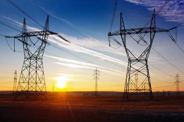 Pilones de electricidad y puesta de sol — Foto de Stock