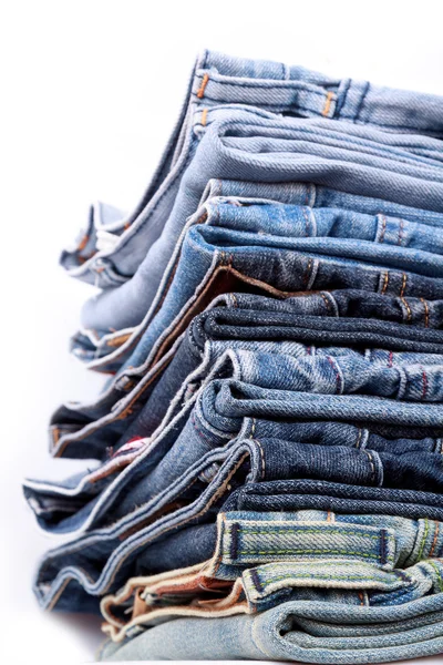 Pila di jeans blu su sfondo bianco — Foto Stock