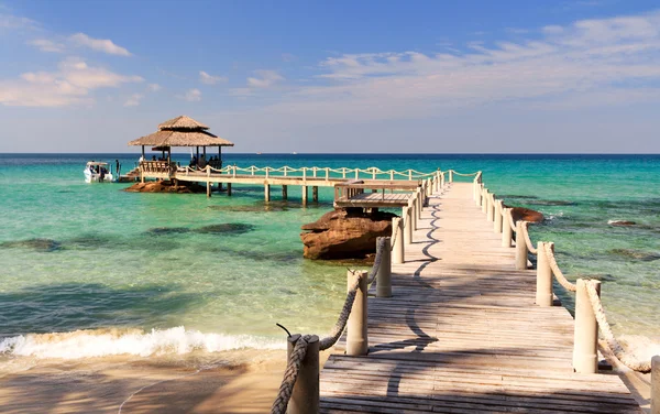 Puente conduce a la playa tropical en un paisaje marino de color turquesa —  Fotos de Stock
