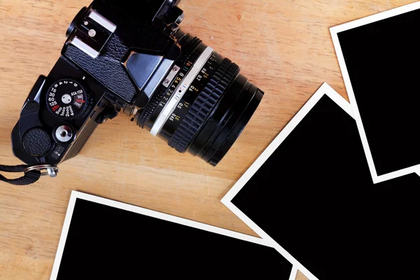 Oude film camera en de foto papier op houten tafel — Stockfoto