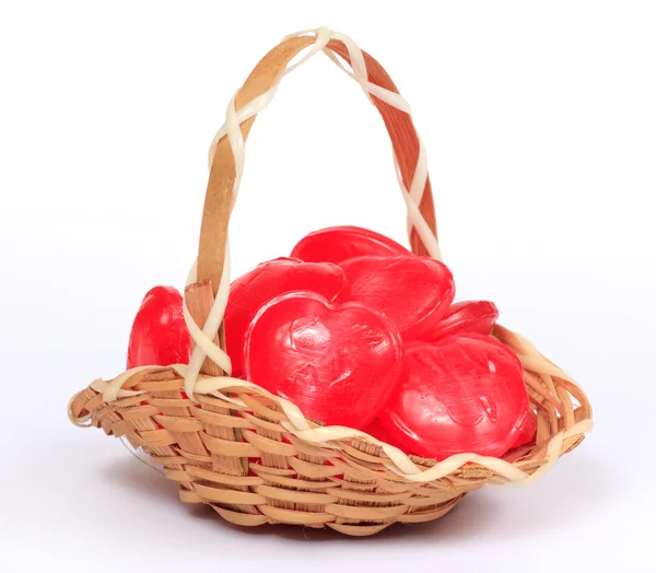 Tiny little wicker basket with heart shape candy — Stock Photo, Image