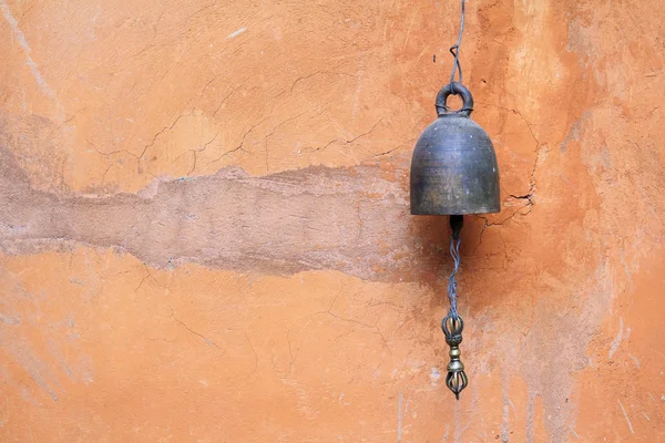 Античный бронзовый колокол на кирпичной оранжевой стене — стоковое фото