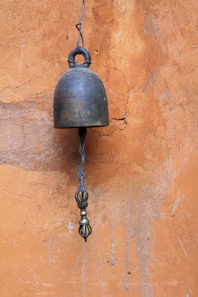 Античный бронзовый колокол на кирпичной оранжевой стене — стоковое фото