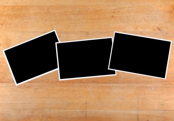 Papel fotográfico en blanco sobre escritorio de madera —  Fotos de Stock