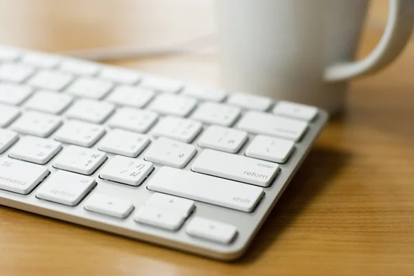 オフィスの環境でモダンなデザインの白いキーボード — ストック写真