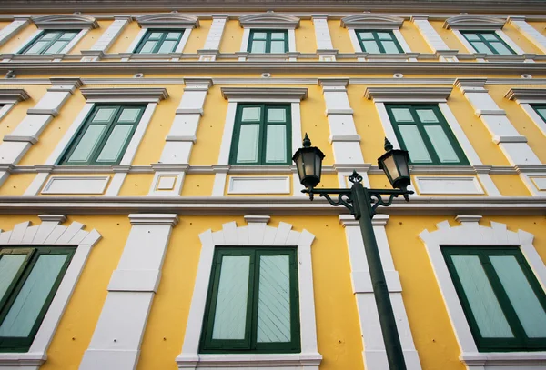 stock image Ancient yellow building with green wooden window in Bangkok