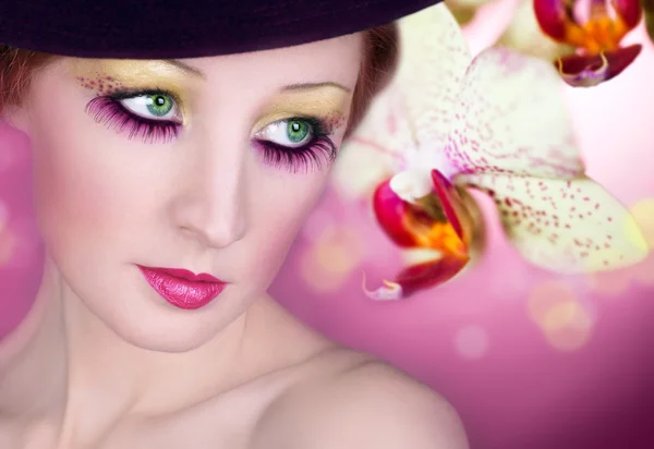 Maquillage lumineux des yeux et fleur d'orchidée — Photo
