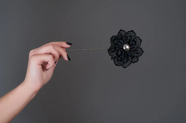 Black artificial flower in woman's hand — Stock Photo, Image