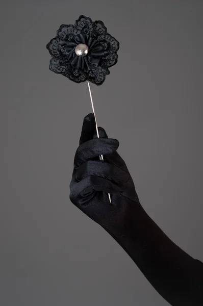 Flor artificial negra en la mano de la mujer — Foto de Stock