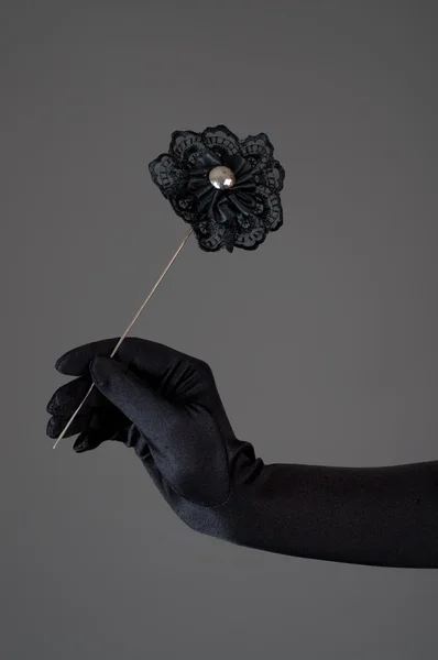 여자의 손에 검은 인공 꽃 — 스톡 사진