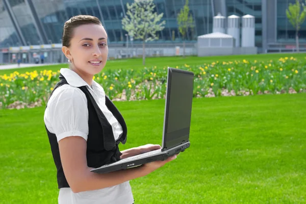 Uśmiechnięta młoda kobieta trzyma laptopa — Zdjęcie stockowe