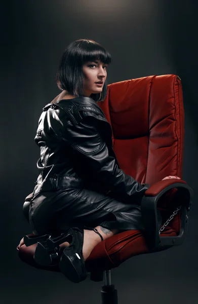 Brünette Frau im roten Sessel — Stockfoto