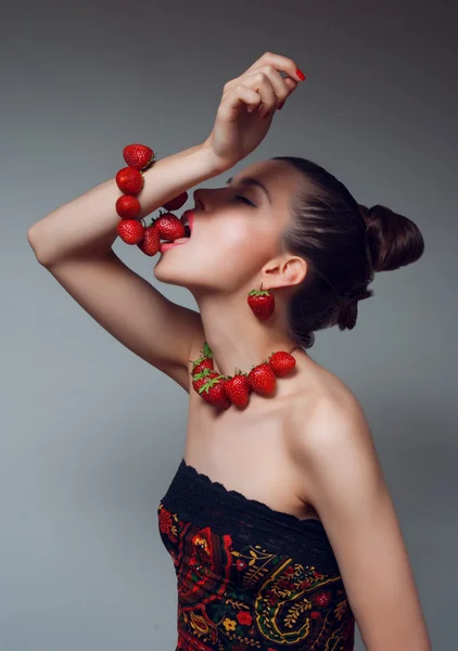 年轻漂亮的女人吃草莓手链室画像 — 图库照片