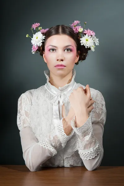 Νεαρή όμορφη γυναίκα σε λευκή μπλούζα και λουλούδια — Φωτογραφία Αρχείου