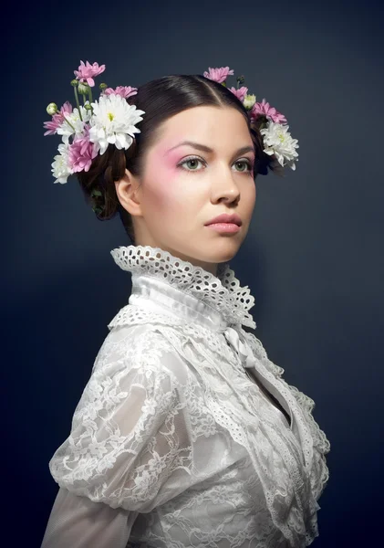 Νεαρή όμορφη γυναίκα σε λευκή μπλούζα και λουλούδια — Φωτογραφία Αρχείου