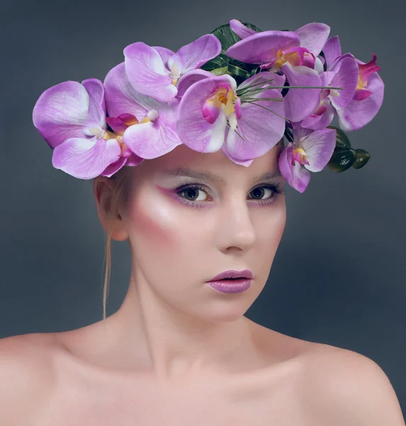 Mooie jonge vrouw met lila bloemen in haar — Stockfoto