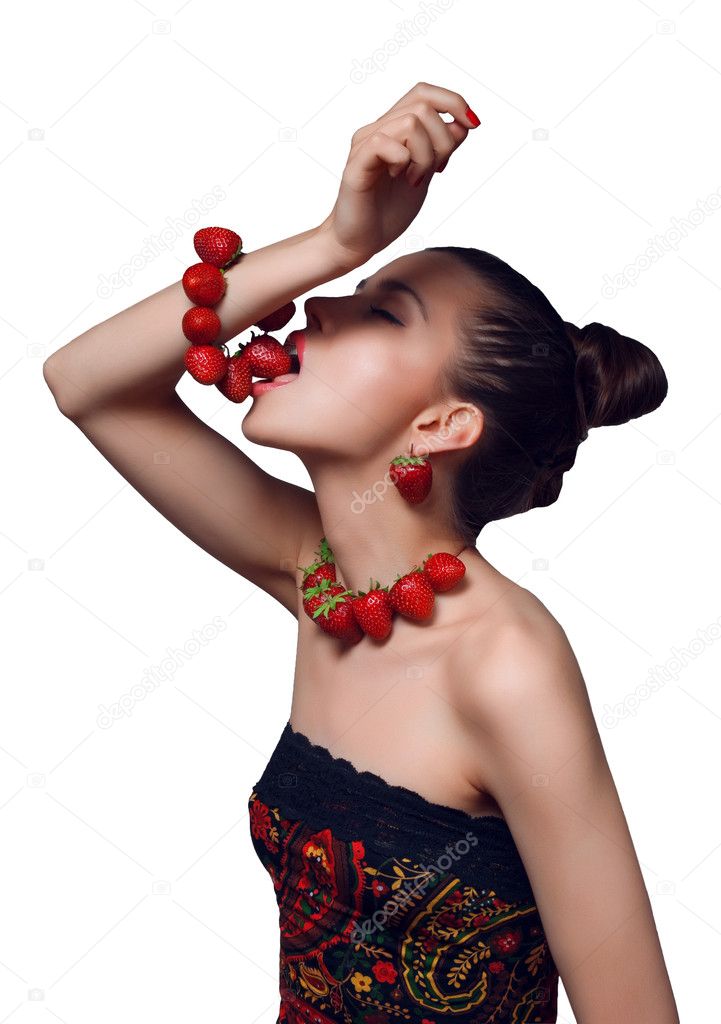 Studio portrait of young beautiful woman eating strawberry bracelet isolated on white