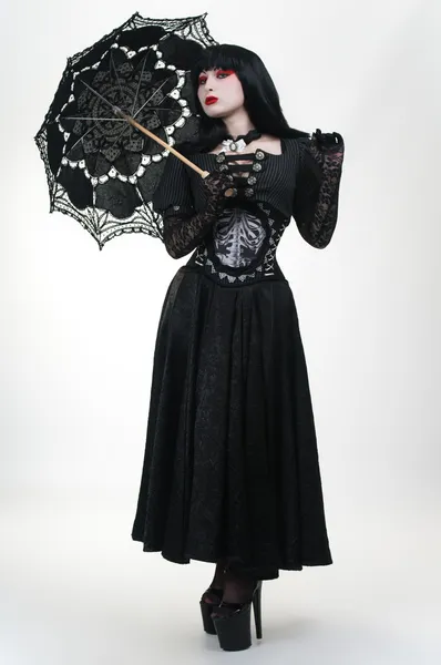 Девушка-вампир в черном платье с зонтиком — стоковое фото