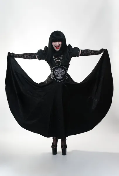 Menina vampiro gótico em preto vestido mosca — Fotografia de Stock