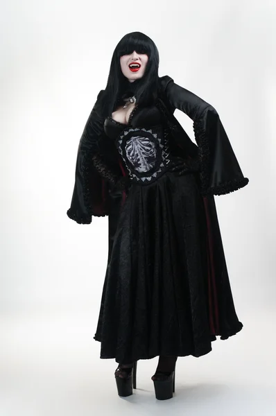Средневековая девушка-вампир в черном платье на белом — стоковое фото