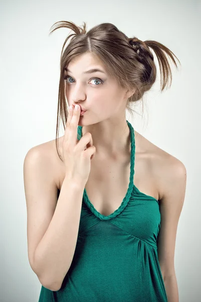 Studio portret van verrast meisje in groene outfit met pigtails — Stockfoto