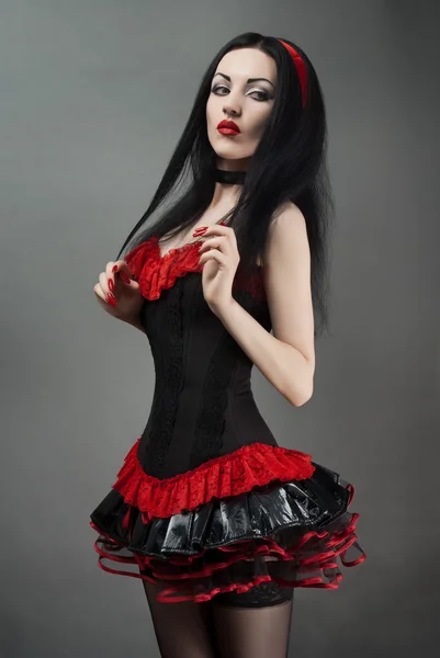 Mujer joven en negro y rojo fetiche traje —  Fotos de Stock