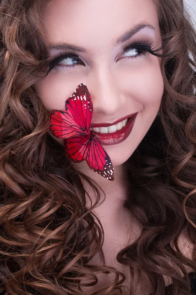 Mulher encaracolada ruiva com borboleta vermelha nos lábios — Fotografia de Stock