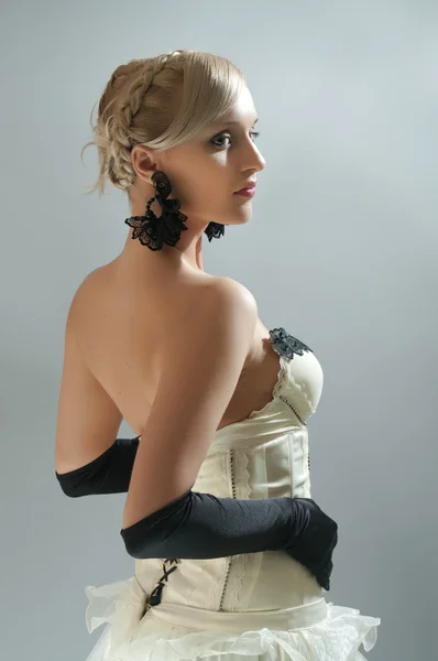 Studio portret van blonde vrouw in witte jurk en zwarte handschoenen — Stockfoto