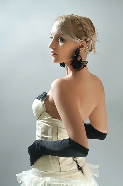 Studio portret van blonde vrouw in witte jurk en zwarte handschoenen — Stockfoto