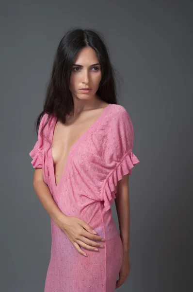 Attraktive brünette Frau im rosa Kleid — Stockfoto