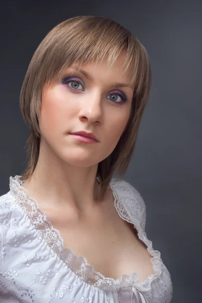 Studio portret van mooie jonge vrouw in witte jas — Stockfoto