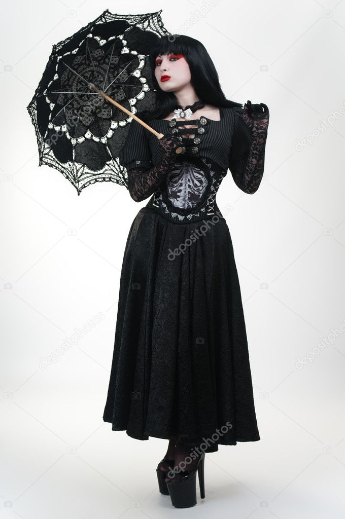 Gothic vampire girl in black dress with umbrella