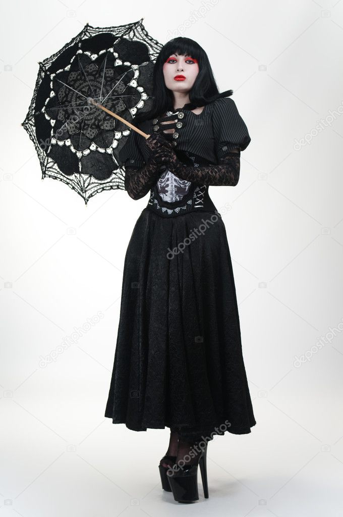 Gothic vampire in black dress with umbrella